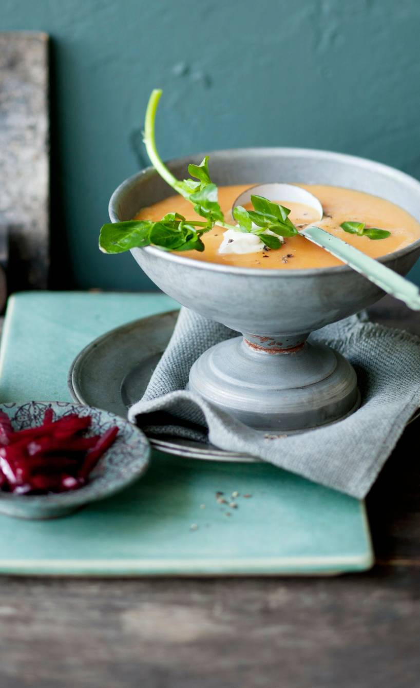 Pastinakensuppe in einer Schüssel, daneben eingelegte Rote Bete auf einem Teller