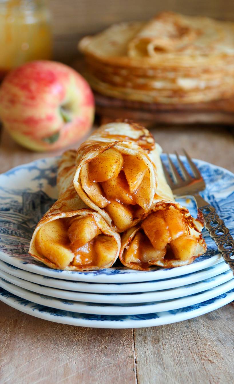 Pfannkuchen mit Apfel-Karamell-Füllung gerollt auf einem Teller