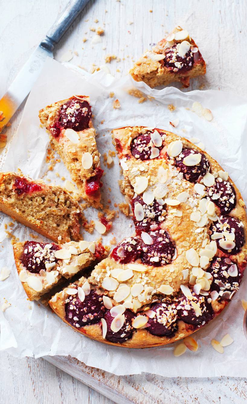 Pflaumen-Buttermilch-Kuchen mit Haferflocken aus der Springform angeschnitten auf einer Kuchenplatte