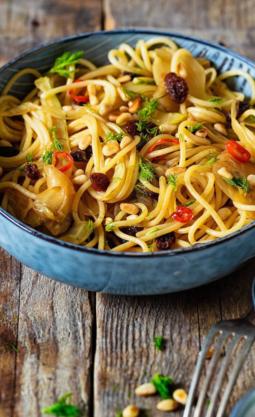 Spaghetti in einem tiefen Teller mit Weißweinsauce, Fenchel und Rosinen