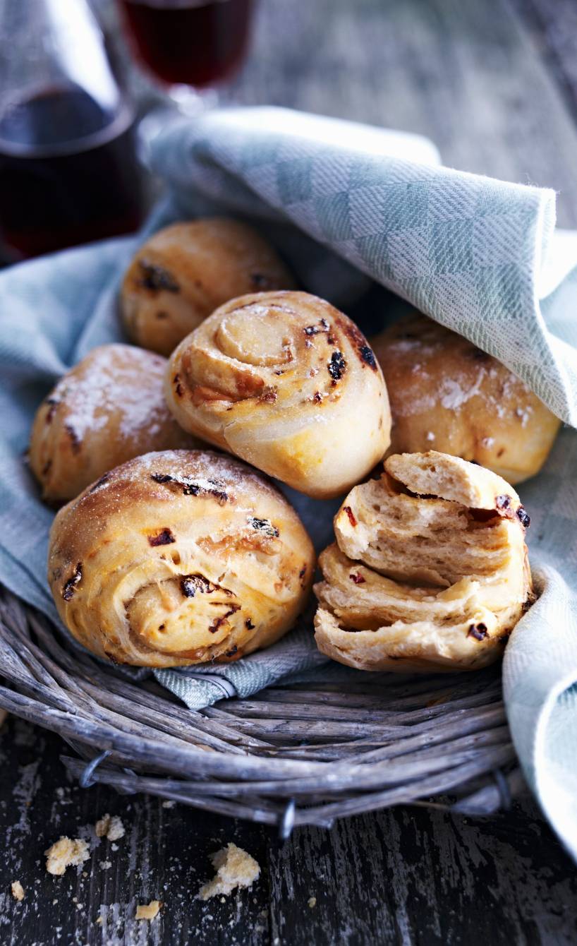 Pizzabrötchen in einem Korb abgedeckt mit einem Küchentuch auf einem Tisch
