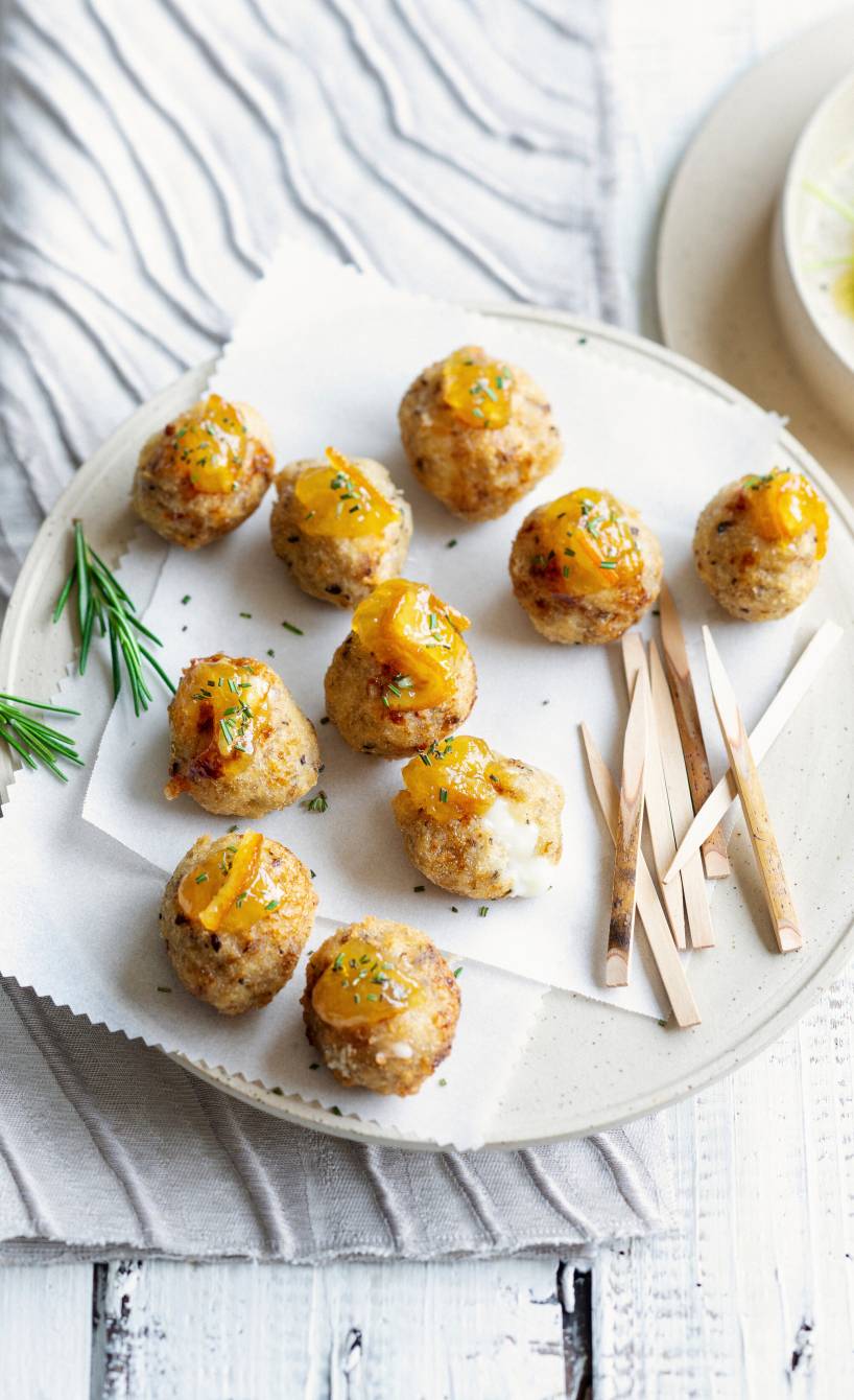 Frittierte Brot-Käse-Bällchen mit Provola-Kern mit einem Klecks Orangenmarmelade auf einer Servierplatte