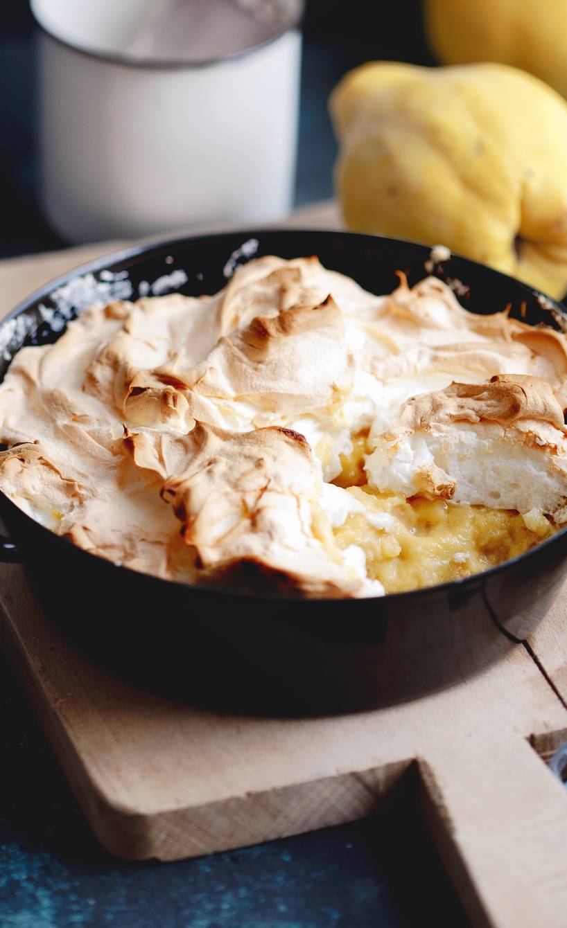 Angeschnittener Grie0auflauf mit Quitten und Baiserhaube in einer gusseisernen Auflaufform