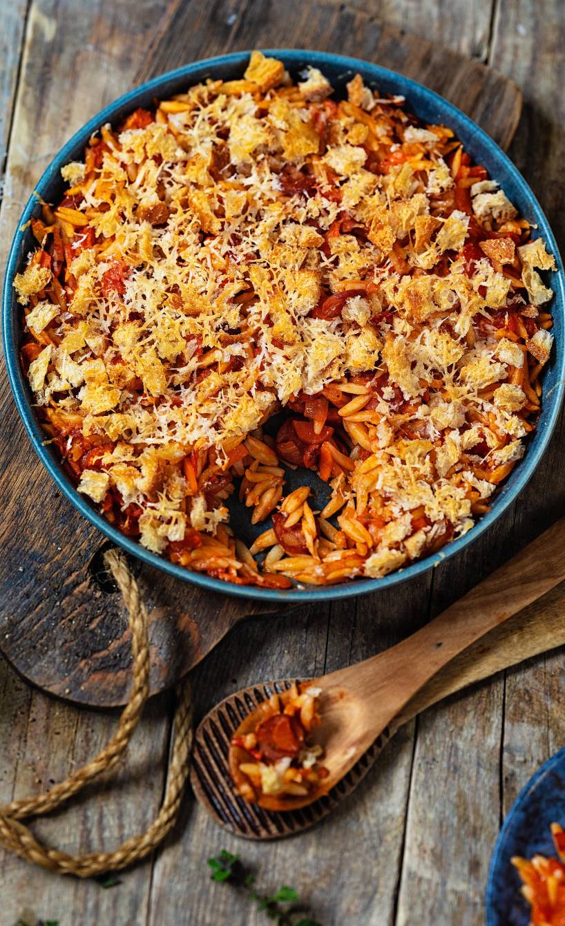 Reisnudelauflauf mit Salsiccia überbacken mit Käsekrümeln auf einem Tisch