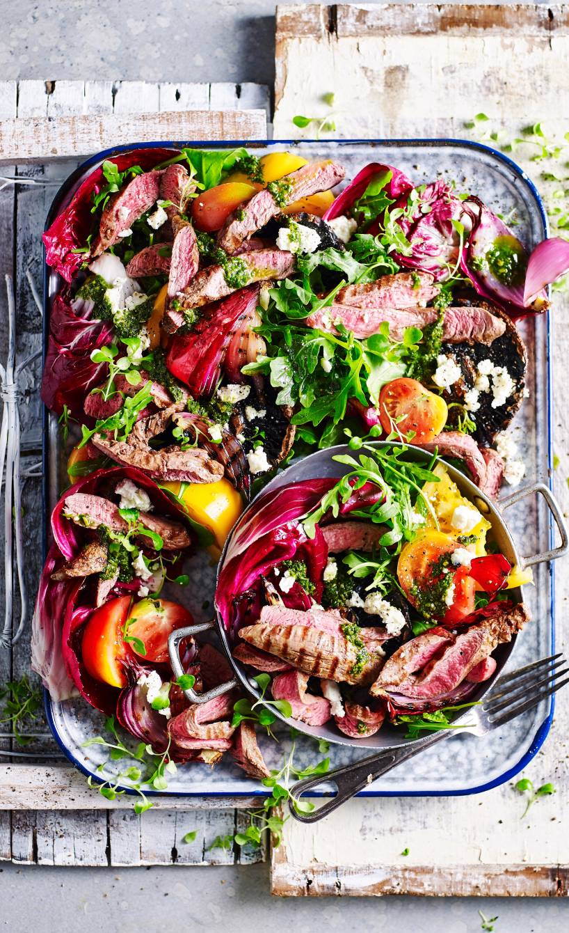 Salat mit Spinatpesto-Dressing getoppt mit Lamm vom Grill in einer rechteckigen Form auf einem Tisch