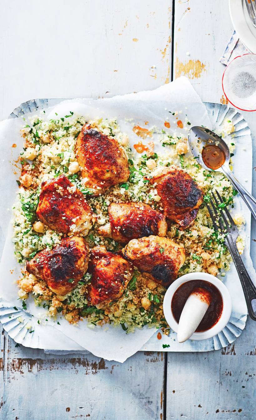 Im Ofen gebackene, marinierte Hähnchenkeulen auf einem Mix aus Couscous und Kichererbsen