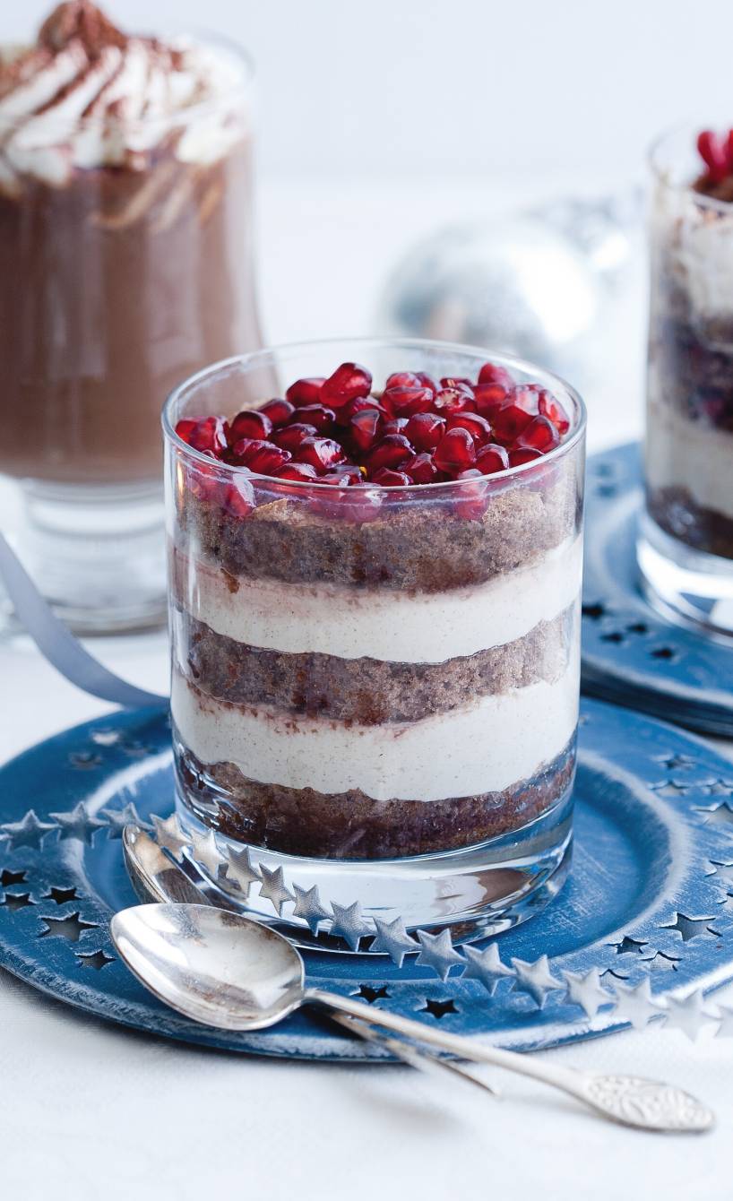 Schoko-Zimt-Dessert in ein Glas geschichtet auf einem weihnachtlich dekorierten Tisch