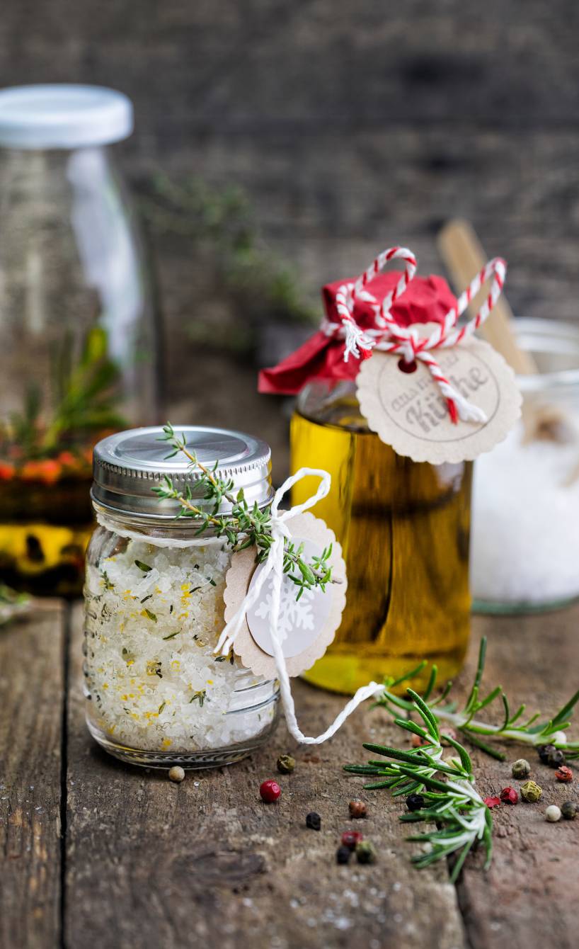 Selbstgemachtes Gewürzset aus italienischem Gewürzöl und Gewürzsalz in weihnachtlich verpackten Gläsern