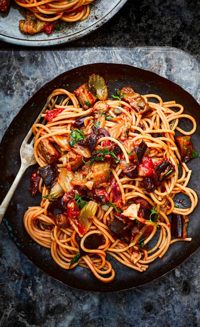 Spaghetti mit sizilianischer Caponata aus Auberginen und anderen Gemüsesorten angerichtet auf einem Pastateller