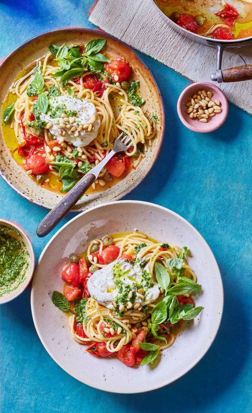Spaghetti angerichtet auf mehreren Pastatellern getoppt von Tomaten, Burrata und Basilikum-Minz-Pesto