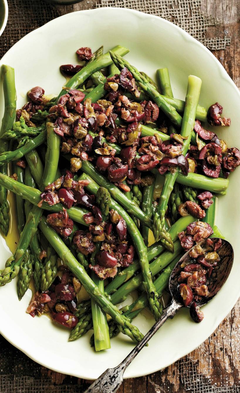 Spargelsalat mit schwarzen Oliven, Sardellen und Kapern auf einer Platte