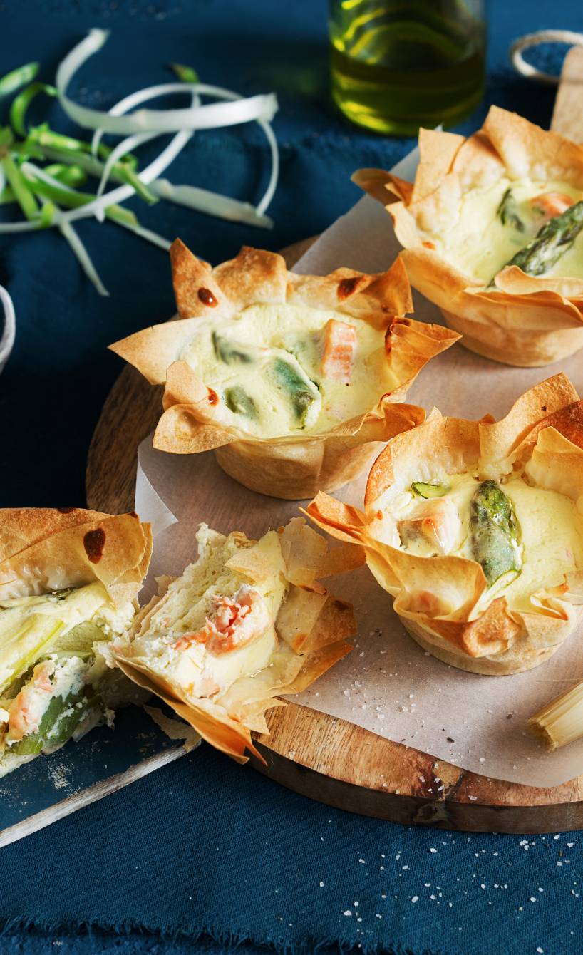 Spargelmuffins aus Filoteig mit Lachs auf einem Holzbrett