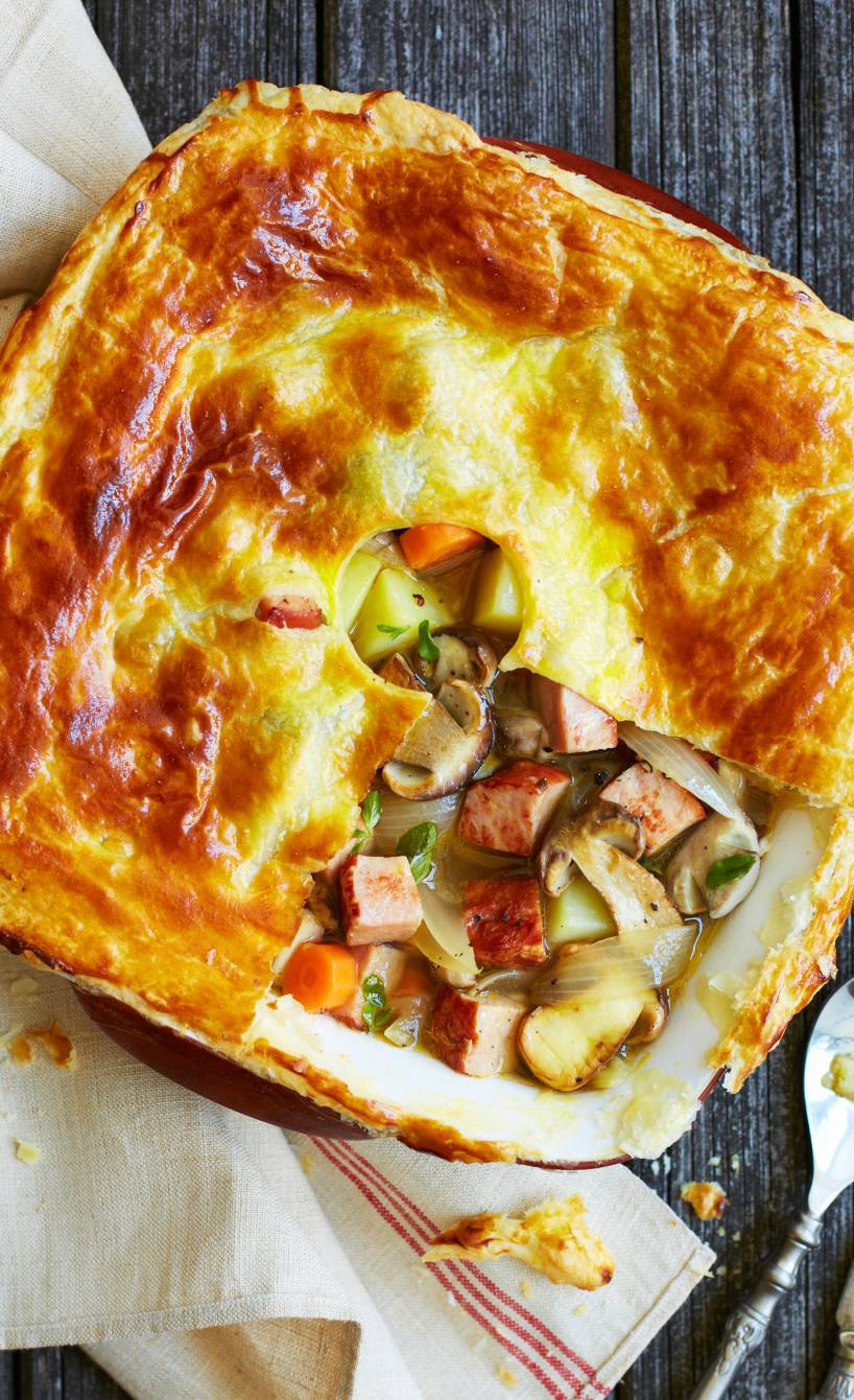 Ragout in einer Auflaufform mit geöffneter Blätterteigdecke, Kasseler, Kartoffeln und Pilzen