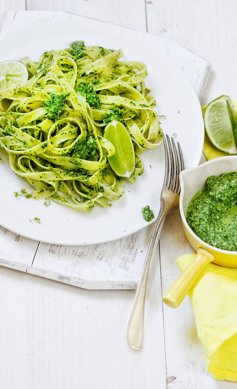 Tagliatelle mit Limetten-Mangoldpesto angerichtet auf einem Teller, daneben Pesto in einer kleinen Schale