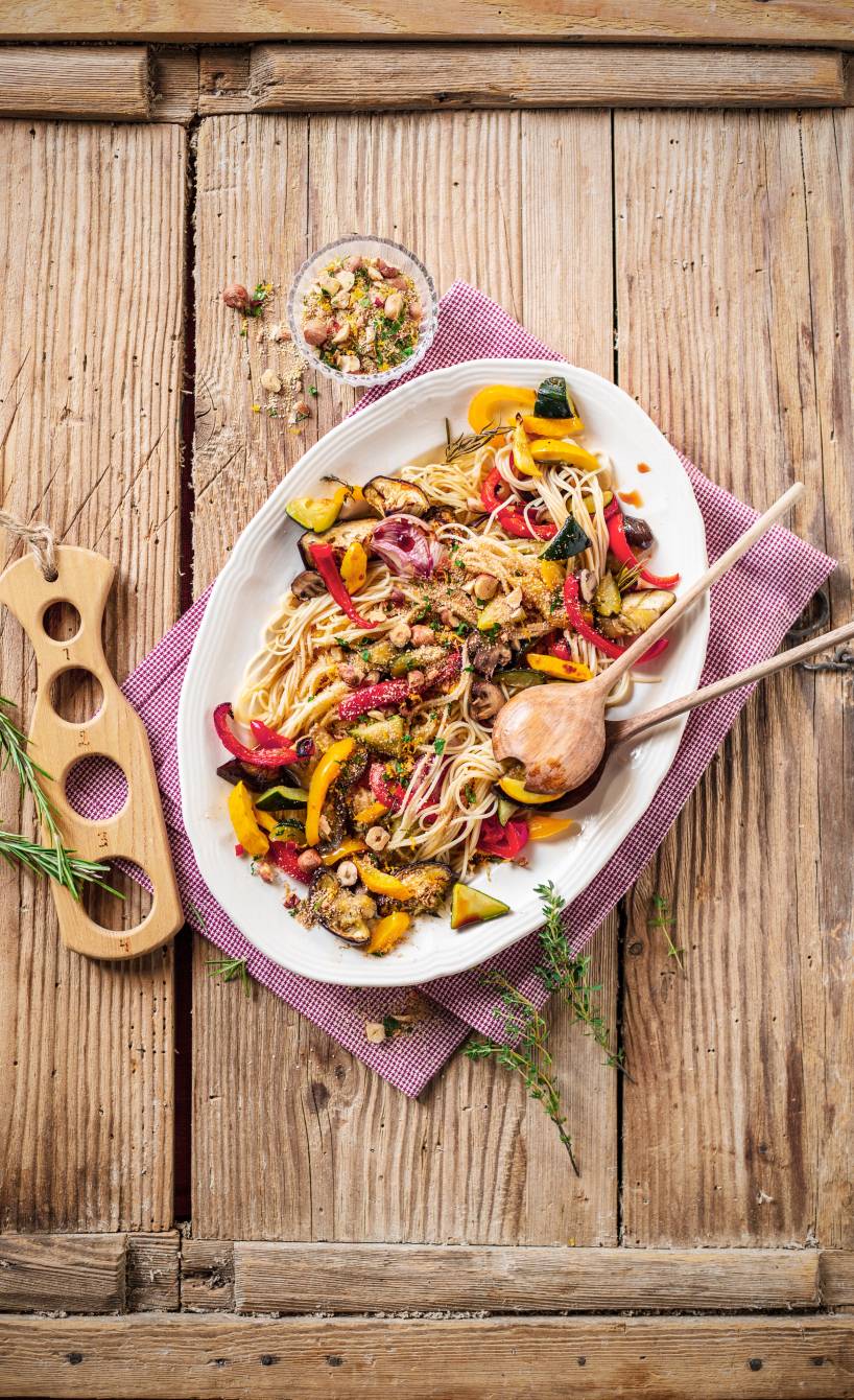 Veganer Nudelsalat mit Antipasti auf einem ovalen Teller