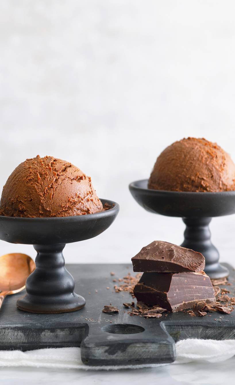 Veganes Haselnuss-Schokoladen-Eis in drei Eisschale auf einer Schieferplatte