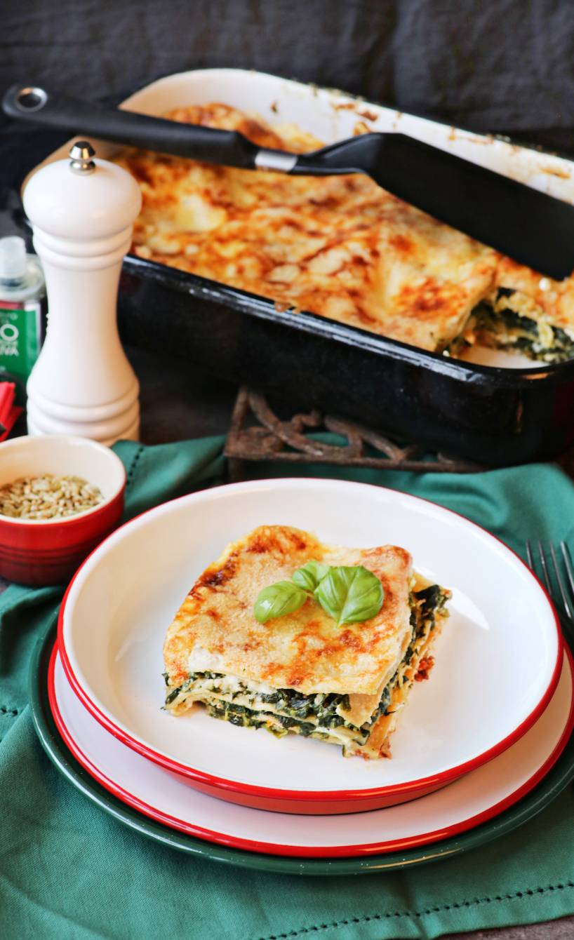 Vollkorn-Spinatlasagne mit Feta in einer Auflaufform auf einem Tisch