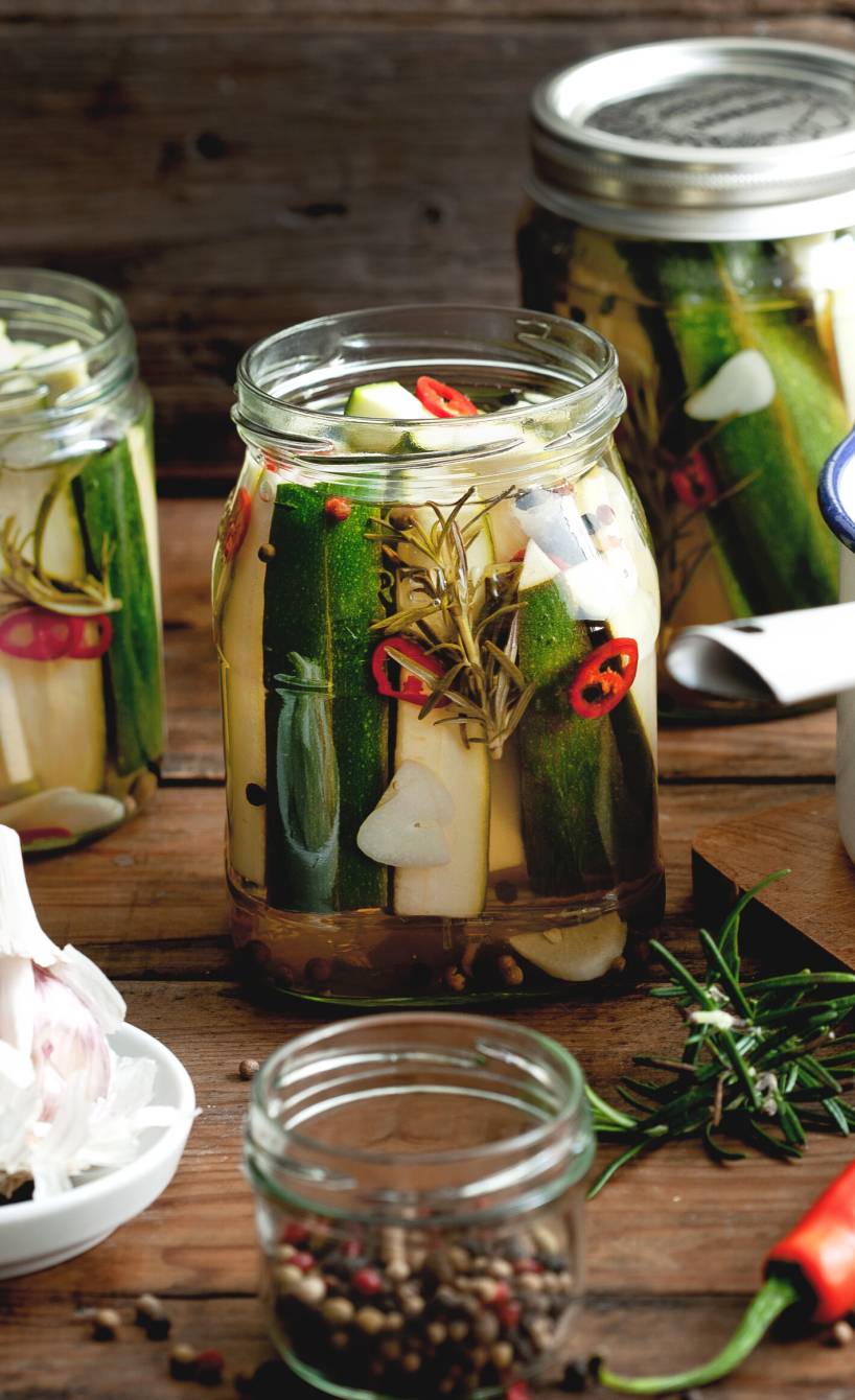 Zucchini eingelegt und in Schraubgläser gefüllt auf einem Tisch