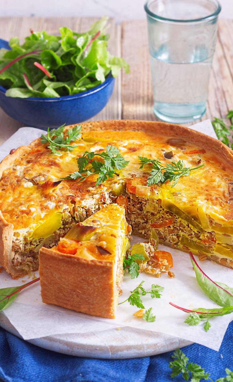 Dinkel-Grünkern-Quiche angeschnitten auf einem Tisch