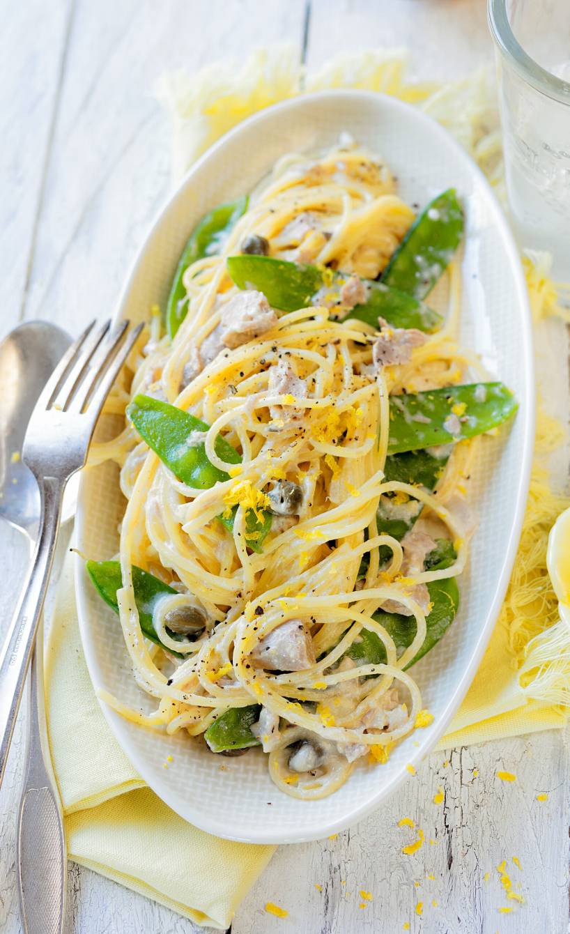 Spaghettini in einer Sauce aus Mascarpone, Zitrone, Thunfisch und Zuckerschoten angerichtet auf einem tiefen Teller