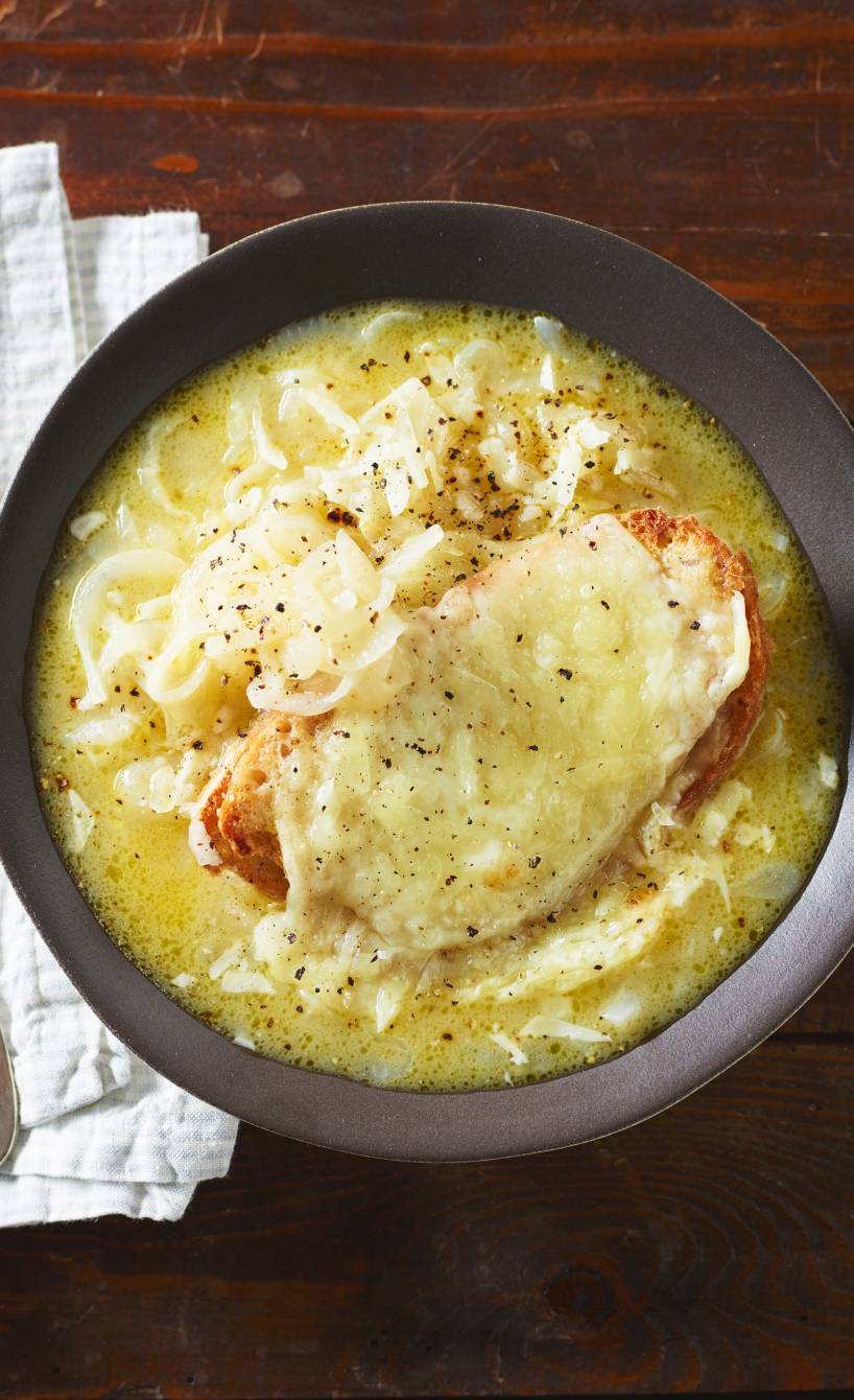 Italienische Zwiebelsuppe in einem Suppenteller getoppt von einer Scheibe mit Käse überbackenem Ciabatta
