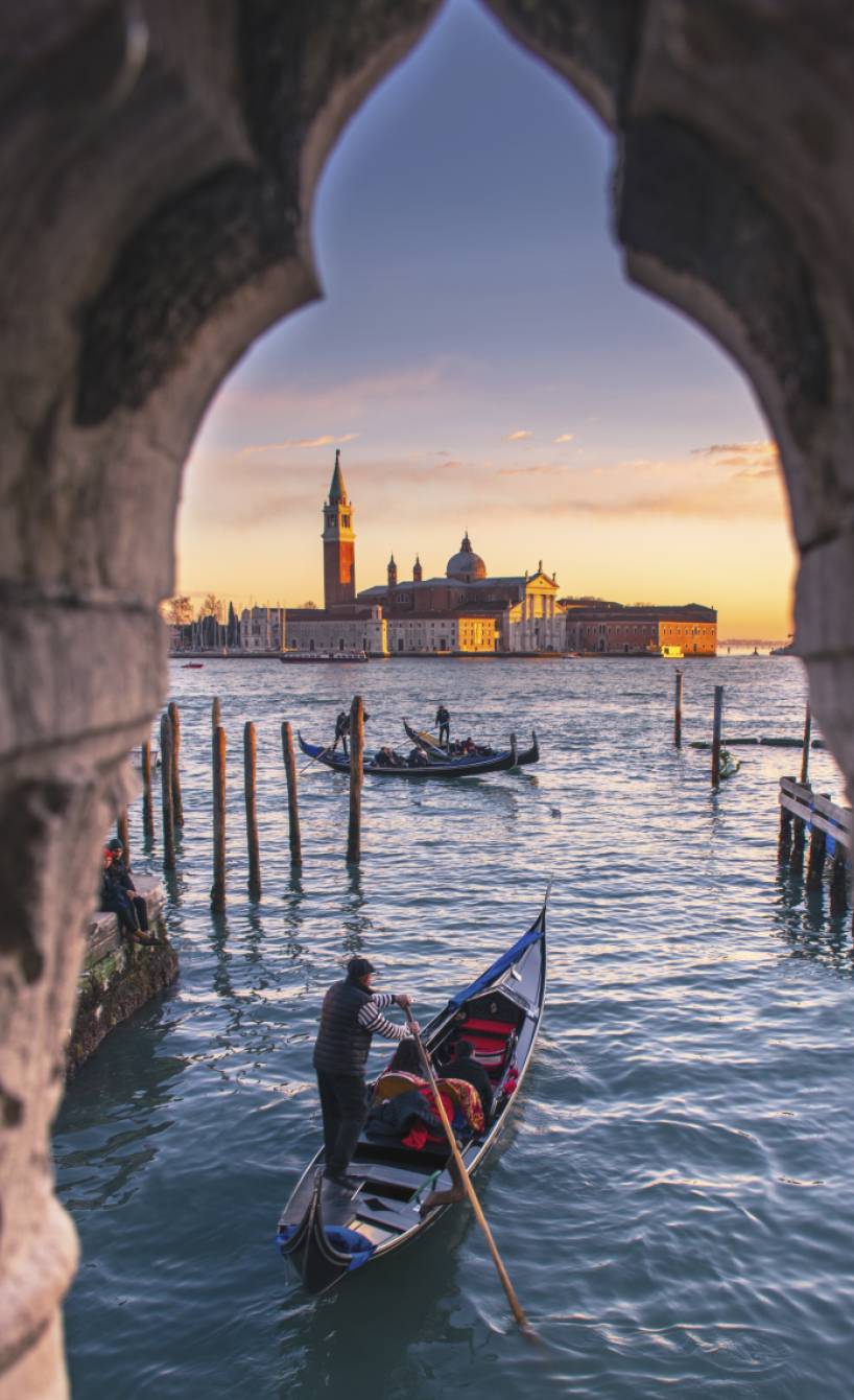 Blick durch ein altes Fenster auf die Wasserstraßen von Venedig