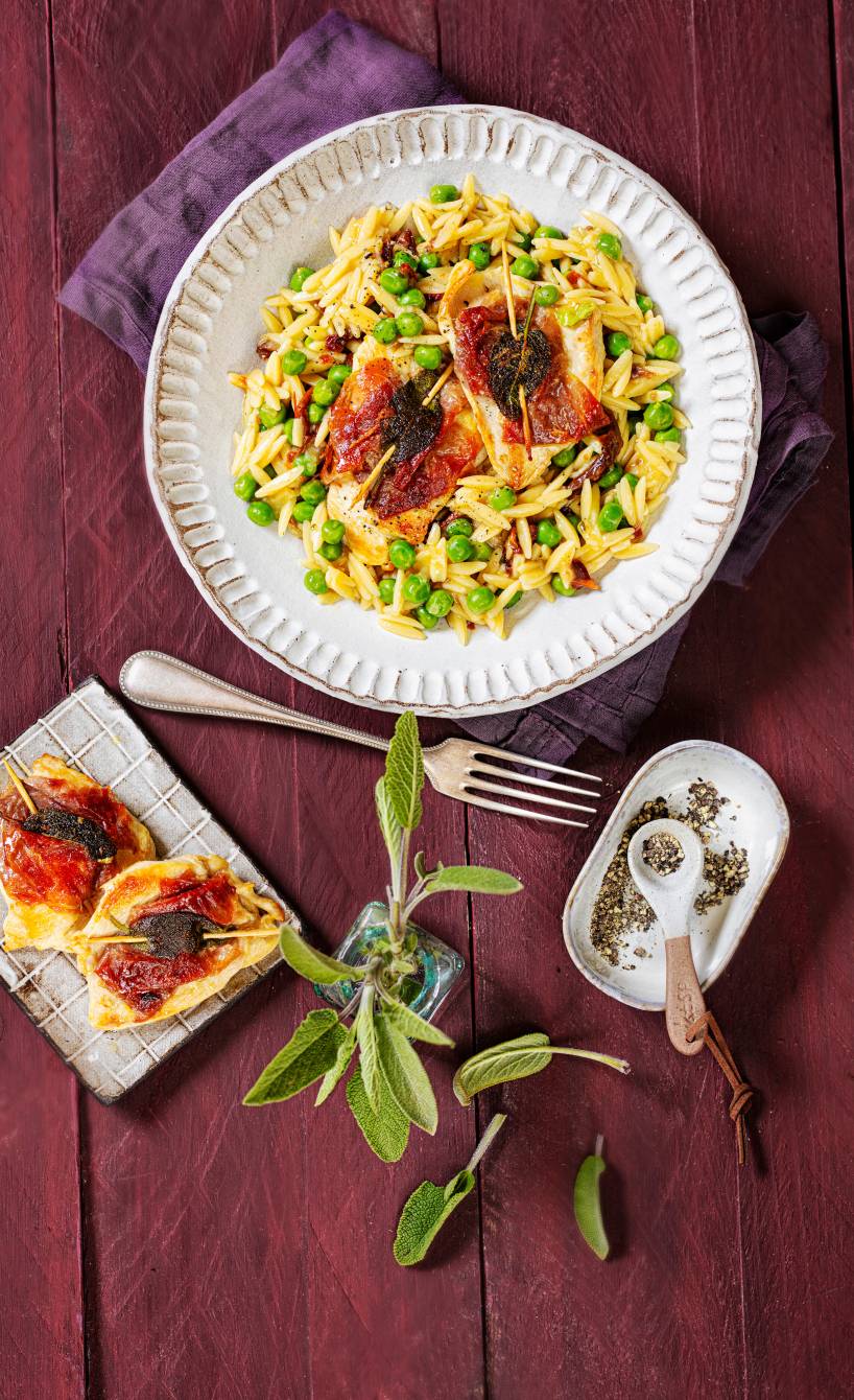Risoni-Pastasotto mit Hähnchen-Saltimbocca angerichtet auf einem Pastateller