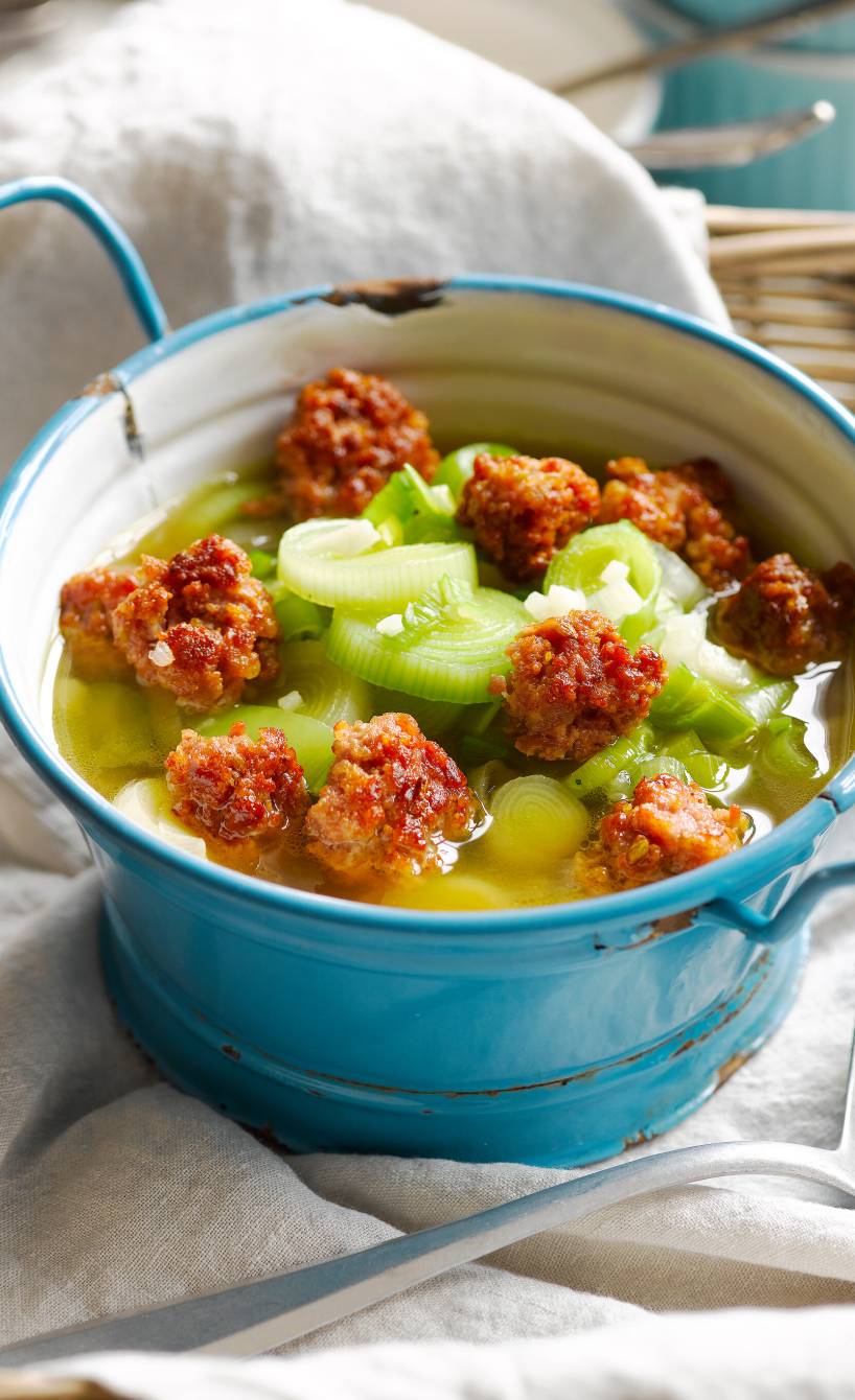 Lauchsuppe in einem Topf getoppt mit Salsicciabällchen