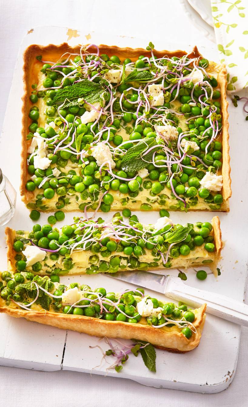 Quiche vom Blech in Streifen geschnitten mit Erbsen belegt