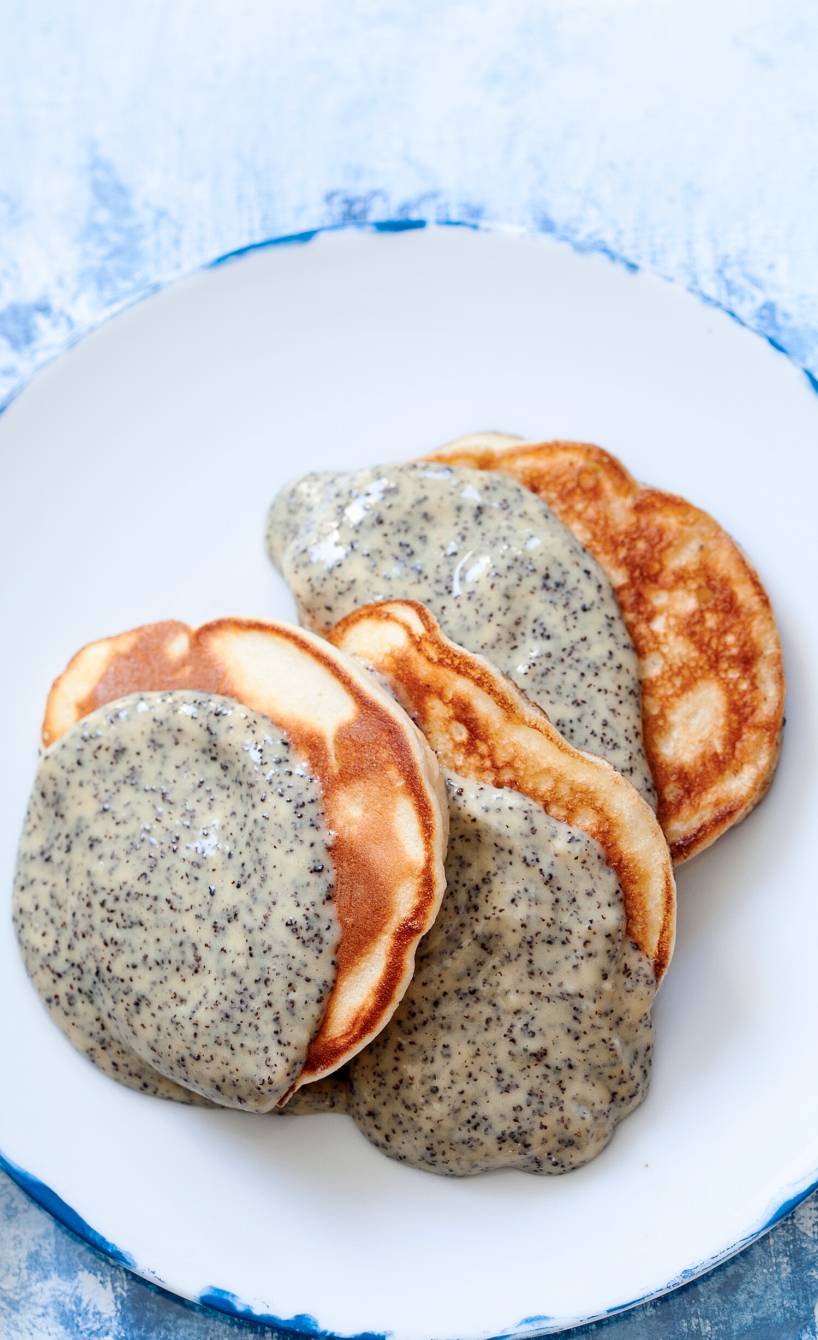 Ricotta-Apfel-Pfannkuchen auf einem Teller getoppt mit Mohnsoße