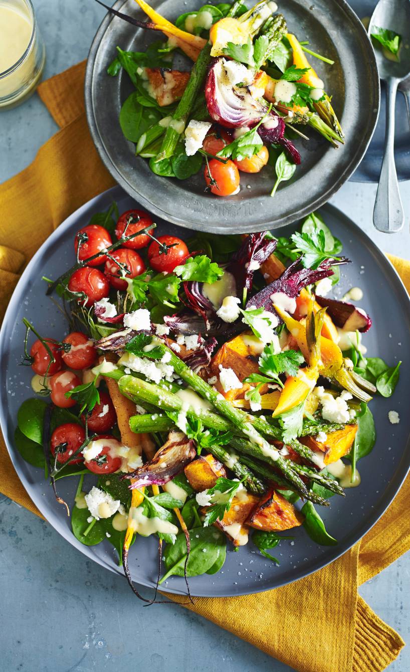 Gebackener Gemüsesalat mit Feta, Rote Bete und Süßkartoffel angerichtet mit Dressing auf zwei Salattellern