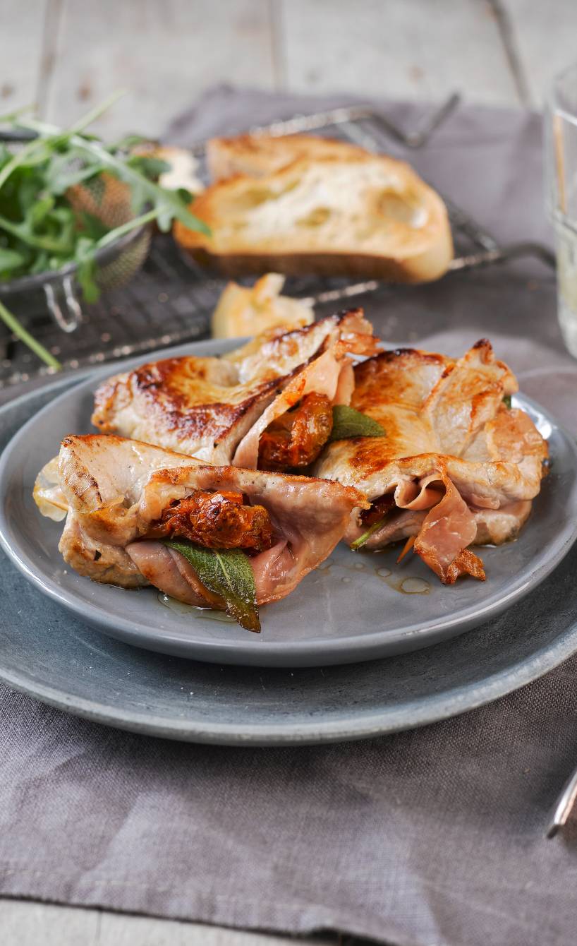 Saltimbocca vom Kalb eingewickelt in Schinken auf einem Teller