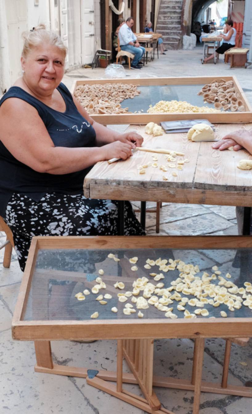 Zwei Frauen in eiener Gasse in Apulien fertigen Pasta an