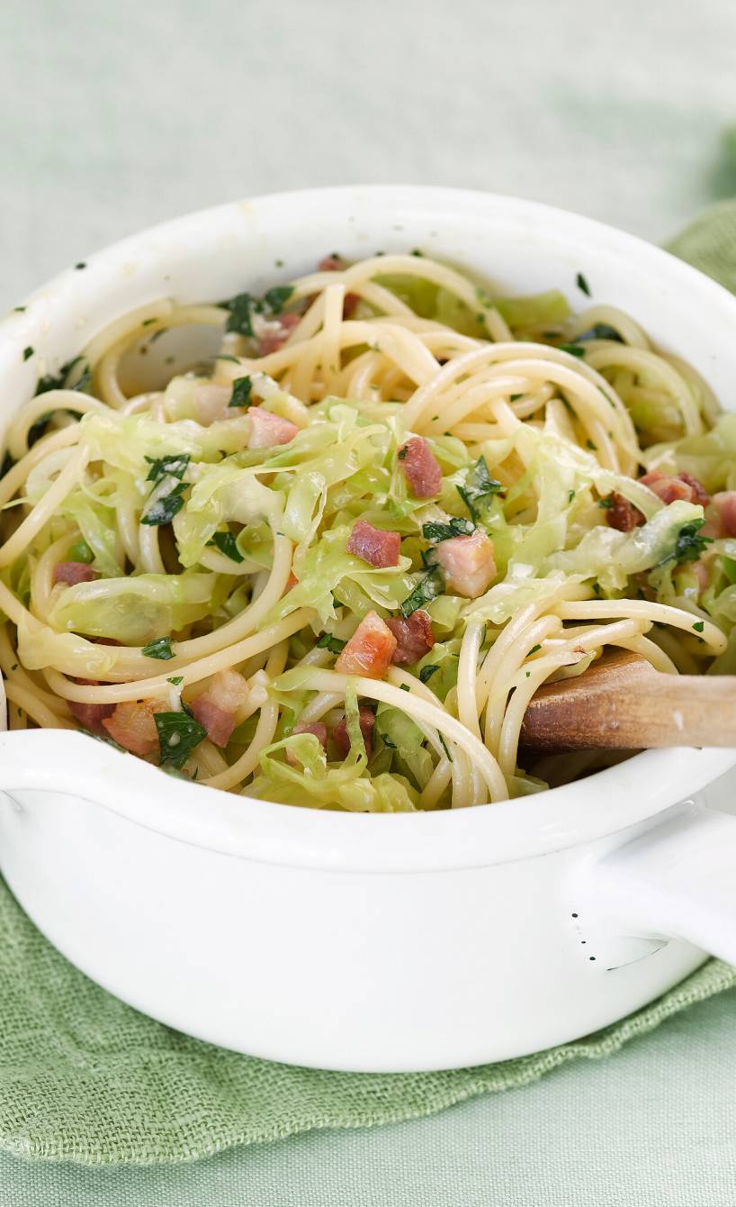 Spitzkohl-Spaghetti-Mischung in einer Schüssel mit Carbonara-Sauce