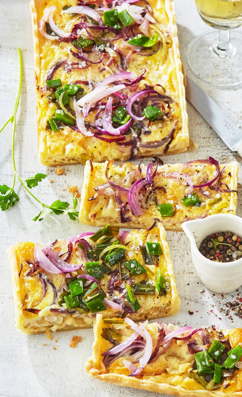 Rechteckige Zwiebelquiche in Streifen geschnitten auf einem Teller