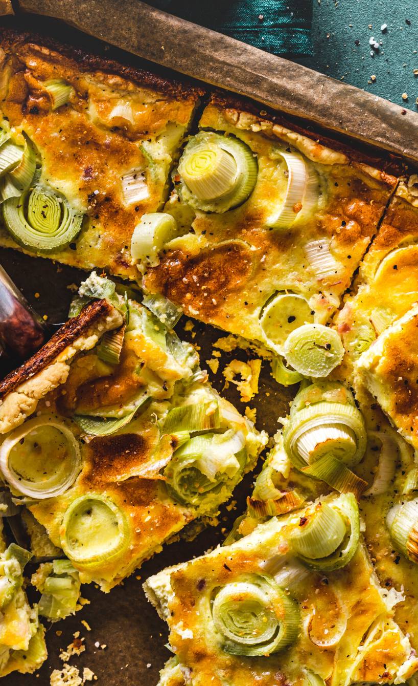 Quiche Lorraine auf einem Backblech in Quadrate geschnitten