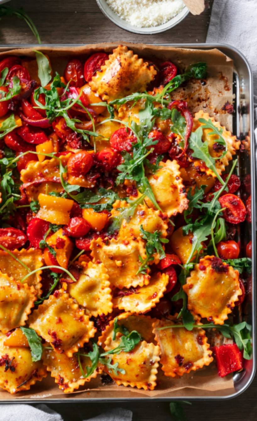 Ravioli in einer Sauce mit Tomatenmark auf einem Backblech