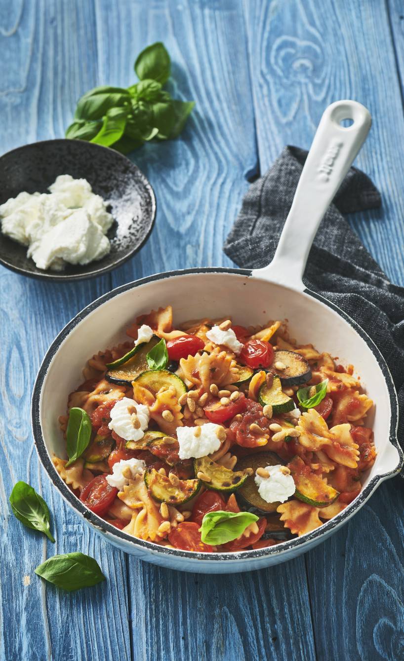 Pasta in selbstgemachter Sugo mit Gemüse und Käse in einer Pfanne auf einem Tisch