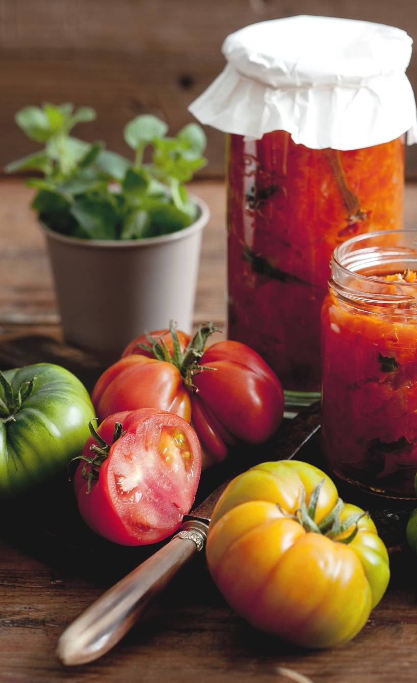 Bunte Tomaten und diverse Tomatensaucen auf einem Tisch