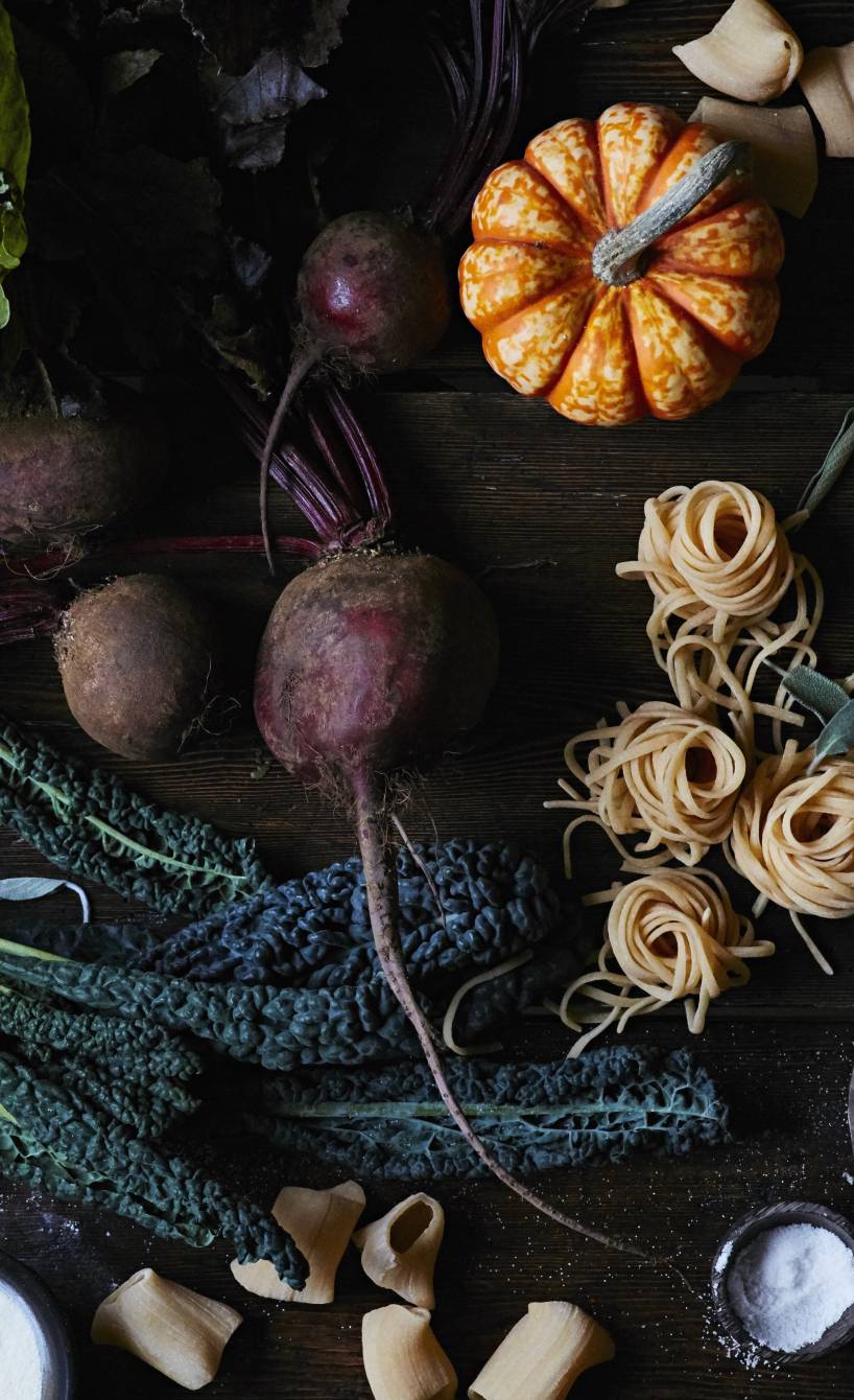 Saisonale Zutaten für den Herbst sowie andere für gesunde italienische Gerichte auf einem Holztisch