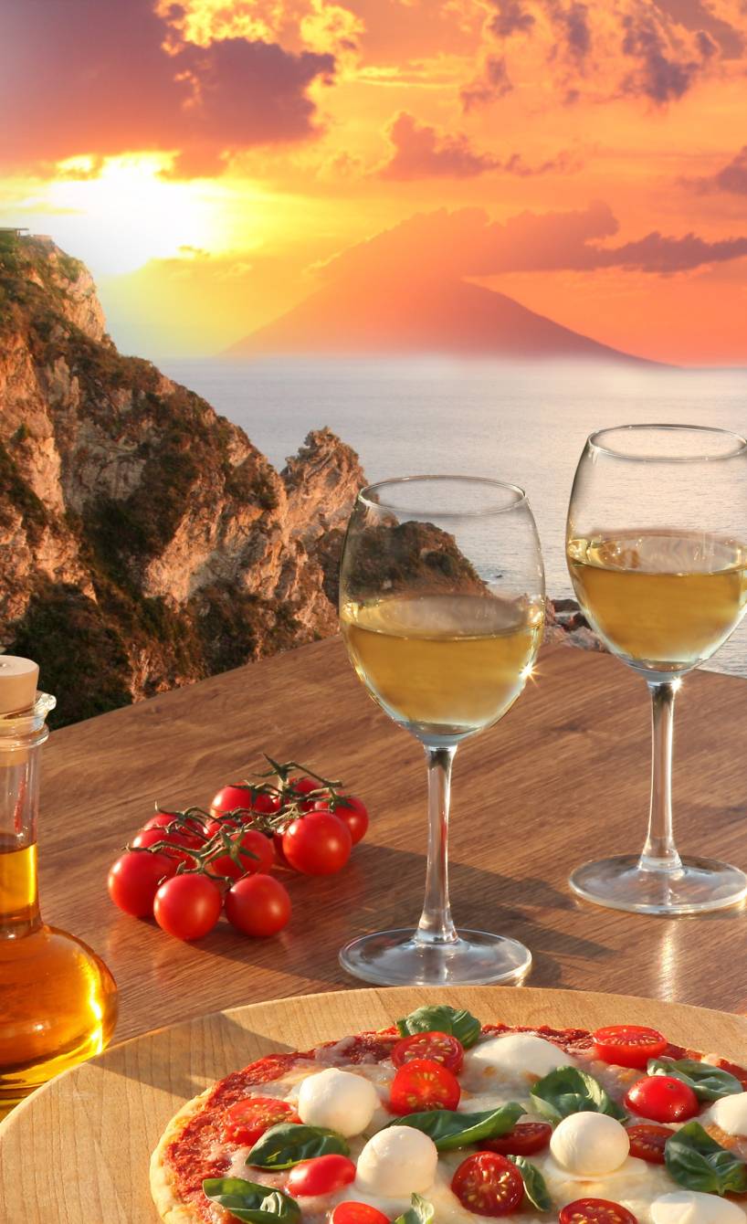 Sonnenuntergang am Capo Vaticano, davor ein Tisch mit Antipasti und Wein