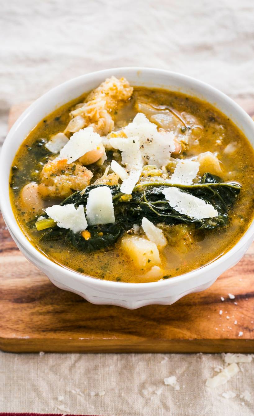Kohlsuppe in einer Suppenschale mit Einlage aus Brot und Kohl getoppt mit Parmesanspänen