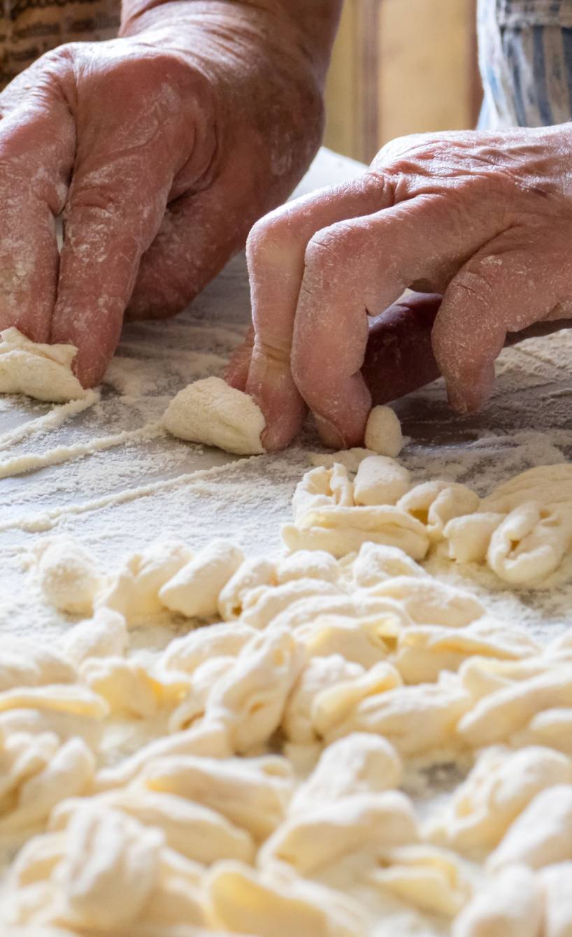 Hände einer älteren Italienerin wie sie original Conchiglione-Pasta selber macht
