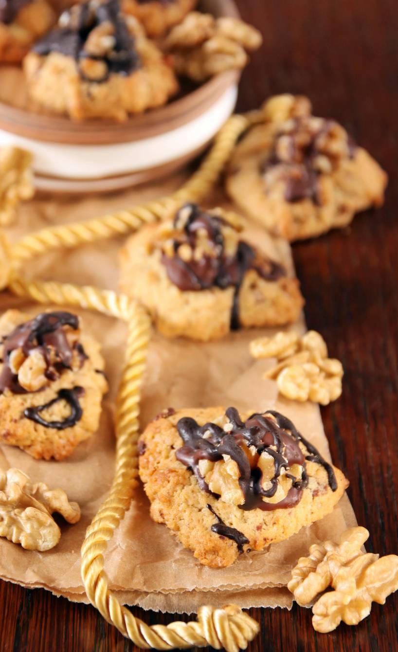 Walnussplätzchen auf einem Stück Backpapier auf einem Holztisch