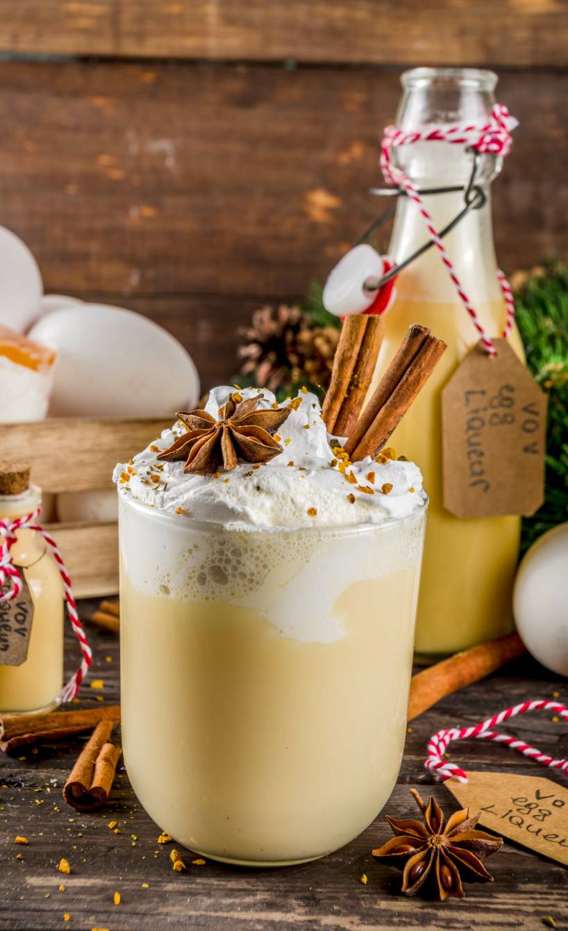 Bombardino in einem Glas, daneben eine Flasche abgefüllt mit geschenkband versehen
