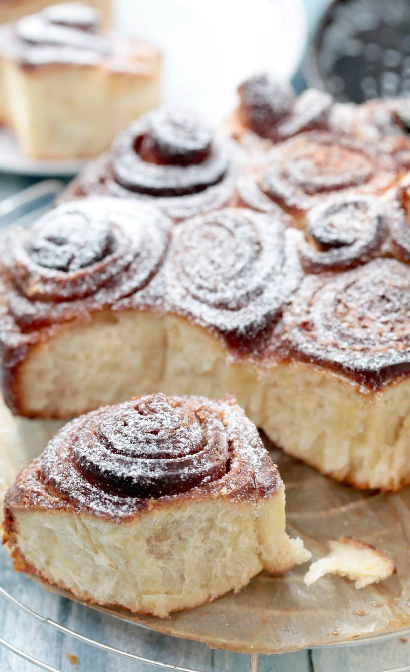 Girelle alla Cannella auf einem Kuchengitter mit Puderzucker bestäubt