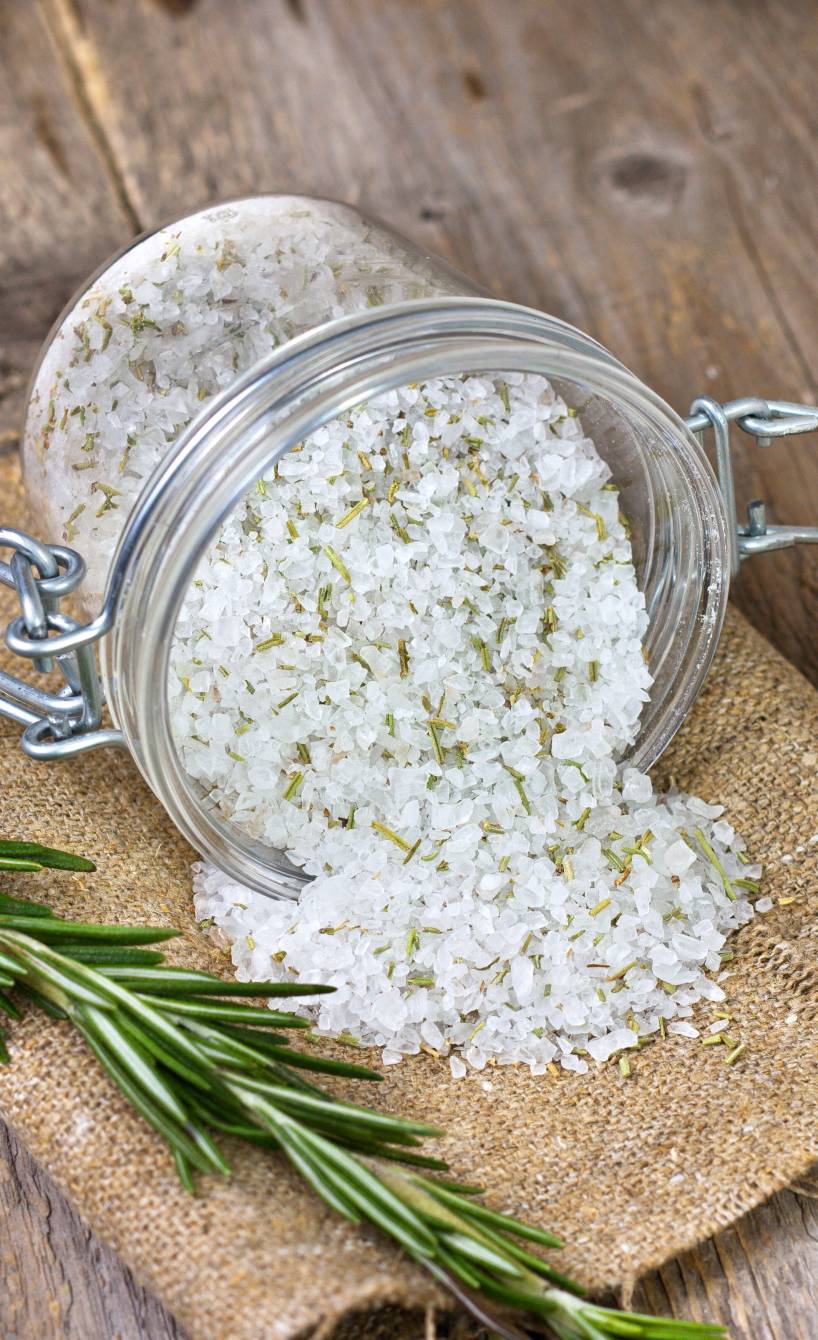 Selbst gemachtes italienisches Gewürzsalz in einem Weckglas, daneben frische Kräuter