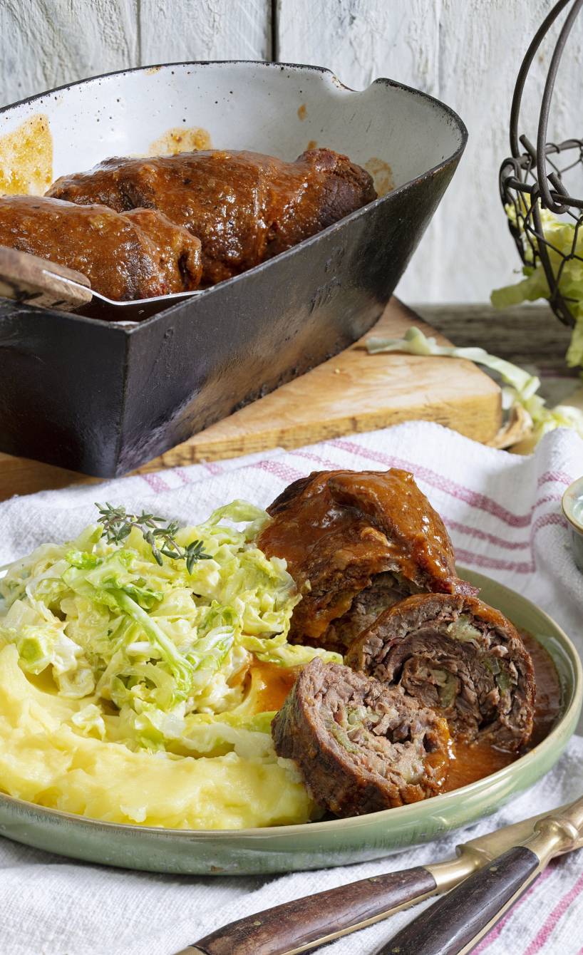 Rinderrouladen und Gemüse auf einem Teller, daneben Sauce