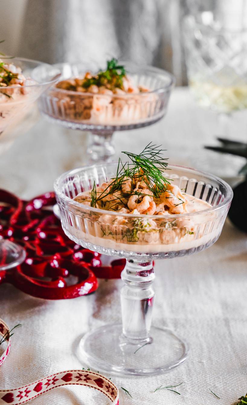 Krabbencocktail in Sektgläsern angerichtet auf einem weihnachtlich dekorierten Tisch