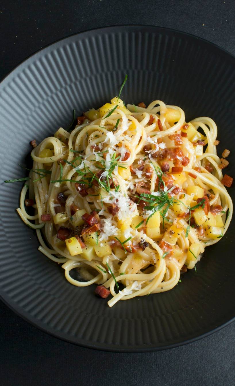 Pasta e patate in einer tiefen Schüssel auf einem schwarzen Tisch